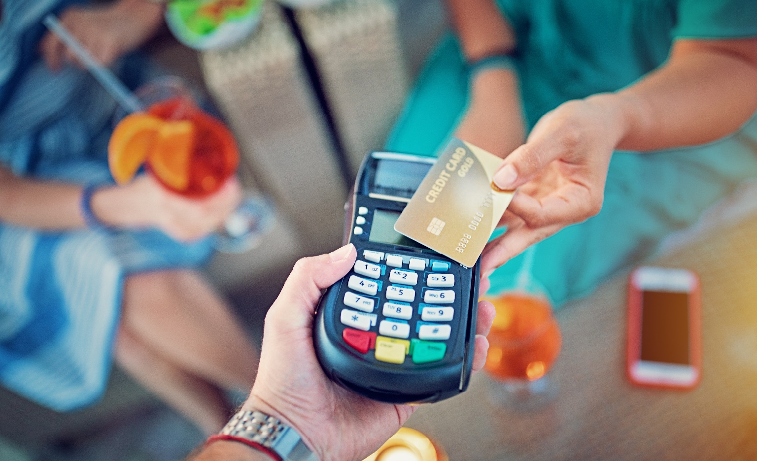 Person paying with their credit card for tropical looking drinks